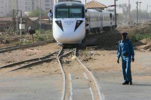 A member of the security forces stands near the tracks as the new Nile Train passes through Khartoum